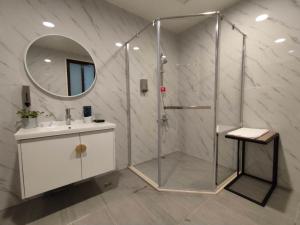 a bathroom with a shower with a sink and a mirror at February Flower B&B in Dongshan