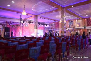 Blue Diamond Resort & Hotel في مظفربور: غرفة بها مجموعة من الكراسي ومسرح
