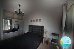 a bedroom with a black bed and a mirror at SEA HOME vue mer in Cassis