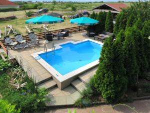 una vista aérea de una piscina con sillas y sombrillas en Ferienhaus Magyar, en Lovas