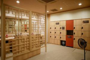 Habitación con taquillas y ventilador. en Dormy Inn Kobe Motomachi Natural Hot Springs, en Kobe