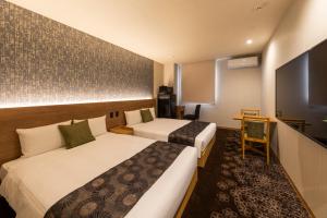 a hotel room with two beds and a desk at Chiyokura HOTEL SHUKU Nagoya in Nagoya +47 photos