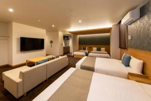 名古屋的住宿－GRAND BASE -Nagoya Chiyokura-，酒店客房设有两张床和一台平面电视。