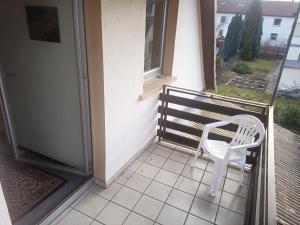 białe krzesło siedzące na ganku domu w obiekcie Haus Theresia w mieście Kleinostheim