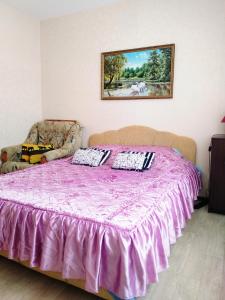 a purple bed with two pillows on top of it at LikeHome Apartments in Velikiy Novgorod