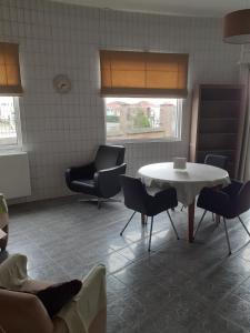 Boutersem的住宿－Wenceslas cobergher appartement I，一间设有白色桌子和椅子的等候室