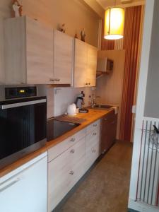 cocina con armarios blancos y microondas negro en Wenceslas cobergher appartement I, en Boutersem