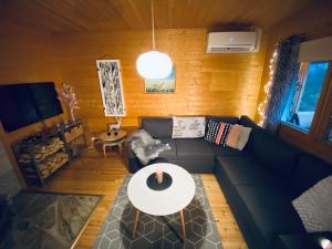 a living room with a couch and a table at Northern Light Villa Ylläs with a Jacuzzi in Ylläsjärvi