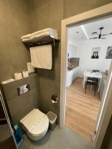 uma casa de banho com WC e uma cozinha com mesa em Arcadia apartment & sea terrace em Odessa