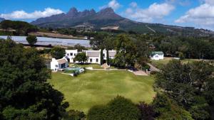 an aerial view of a house with mountains in the background at Avontuur Manor House and Wine Estate in Somerset West