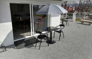 a table and chairs with an umbrella on a patio at Best Price #2 "L'ATELIER" x5 people in Orchamps-Vennes