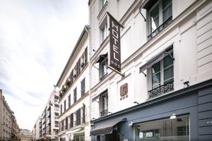 un bâtiment blanc avec un panneau sur son côté dans l'établissement Longchamp Elysées, à Paris
