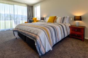 um quarto com uma cama grande e uma janela em Annies on Milford em Te Anau