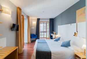 Habitación de hotel con cama grande y ventana en Zenit El Coloquio, en Valladolid