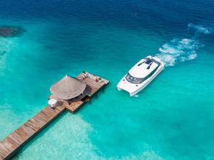 a boat on a dock in the water at OZEN RESERVE BOLIFUSHI - Luxury All Inclusive in Male City