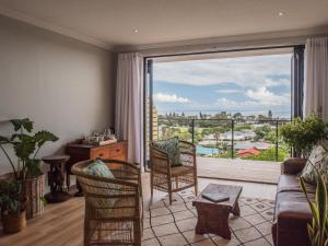 a living room with a couch and a large window at Ridge House in Hermanus