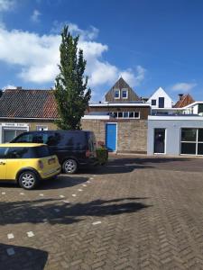 two cars parked in a parking lot in front of a house at Studio Chilltime Harlingen in Harlingen