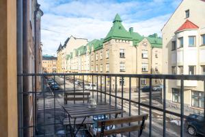a balcony with a table and chairs and buildings at Roost Huvilakatu in Helsinki