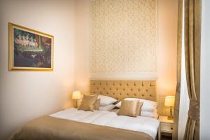 a bedroom with a bed and a painting on the wall at Hotel Bellevue - Liburnia in Opatija