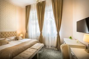 a bedroom with a bed and a window with curtains at Hotel Bellevue - Liburnia in Opatija