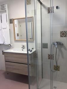 a bathroom with a shower and a sink and a mirror at Casa Navalhorno- barrio nuevo Valsain in Segovia