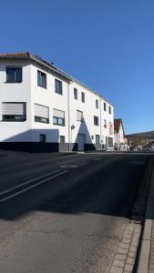 ein weißes Gebäude an der Straßenseite in der Unterkunft Pension Am Amtsgericht in Eiterfeld