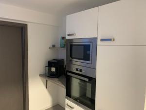 a kitchen with a microwave and a television in it at Pension Am Amtsgericht in Eiterfeld