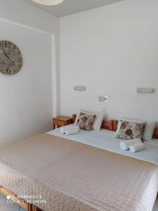 Hotel Orama-Matala في ماتالا: غرفة نوم بسريرين مع ساعة على الحائط