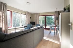 a living room with a couch and a dining room at Bok's Bungalowpark in Garderen