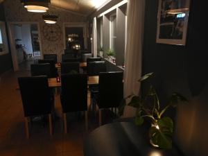 restauracja z długim stołem i czarnymi krzesłami w obiekcie Sjugare Gård Bed & Breakfast w mieście Leksand