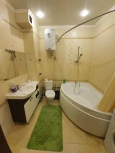a bathroom with a tub and a toilet and a sink at Студия на Володарского 70/ Studio in the center of Kursk in Kursk