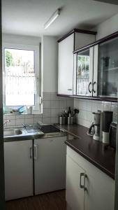 a kitchen with white cabinets and a black counter top at Schwalbe Hochdorf An der Hohlgasse in Freiburg im Breisgau