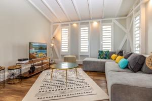 una sala de estar con un sofá y una mesa en Villa du Cap 5 étoiles piscine spa et vue mer exceptionnelle, en Sainte-Anne