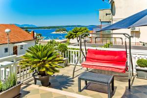 a red chair on a balcony with a view of the water at Apartments Dorijan in Beautiful House in Hvar