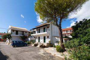 a car parked in front of a white house at Island Kavos Annex studios in Kavos