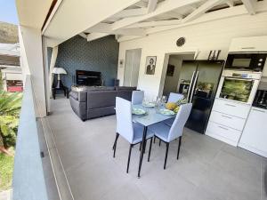 einen Tisch und Stühle auf einer Terrasse mit einer Küche in der Unterkunft From Paris to SXM - luxury next to Anse Marcel Beach in Anse Marcel 