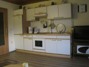 a kitchen with white cabinets and a stove at Ferienwohnung Stilla Traurig in Arrach