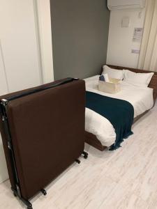 a bedroom with a bed with a box on it at ラ・ルーチェ東仲宗根 in Miyako Island