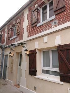 a brick building with wooden doors and windows at Les studios de la faisanderie in Chantilly