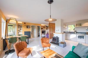 a living room and kitchen with a couch and chairs at Le Chalet in Vresse-sur-Semois
