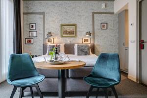 a bedroom with a bed and a table and chairs at Boutique Hotel 't Vosje in Haarlem