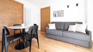 a living room with a couch and a table and chairs at Italianway - Al Forte 6 in Valdisotto