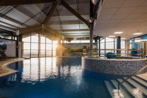 a large swimming pool in a building with a large window at The Bay Hotel in Kinghorn
