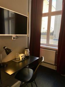 a table and a chair in a room with a window at Unique Hotel Jungfrugatan in Stockholm