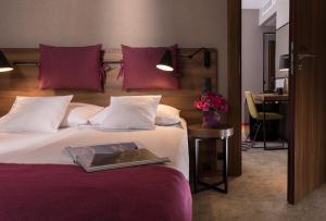 una habitación de hotel con una cama con un libro encima en Hotel Sadova, en Gdansk