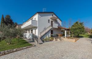 ein großes weißes Haus mit einer Auffahrt in der Unterkunft Apartments Spinotti in Novigrad Istria