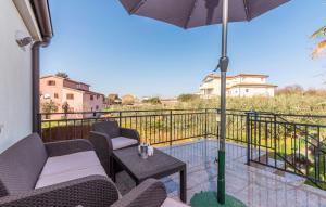 eine Terrasse mit Stühlen, Sonnenschirm und Tisch in der Unterkunft Apartments Spinotti in Novigrad Istria