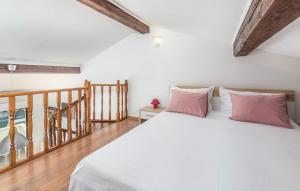 ein Schlafzimmer mit einem weißen Bett mit rosa Kissen in der Unterkunft Apartments Spinotti in Novigrad Istria