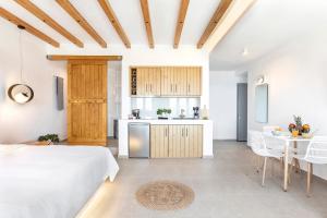 a kitchen and a bedroom with a bed and a table at La Estrella Luxury Suites in Vourvoúlos