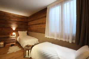 sypialnia z 2 łóżkami i oknem w obiekcie Petit Chalet Blanc Cervinia w mieście Breuil-Cervinia